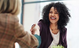 A foundation executive welcomes a new hire with a handshake