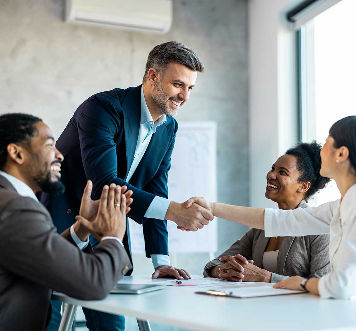 A newly hired Executive Director of a nonprofit shakes the hands of his new team members